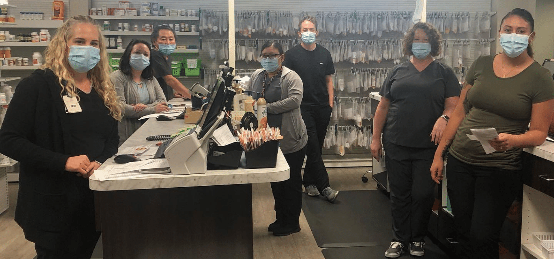 Staff in pharmacy setting with masks.